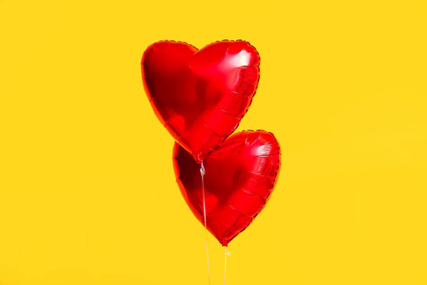 Beautiful heart-shaped balloons for Valentine's Day celebration on yellow background - 写真・画像