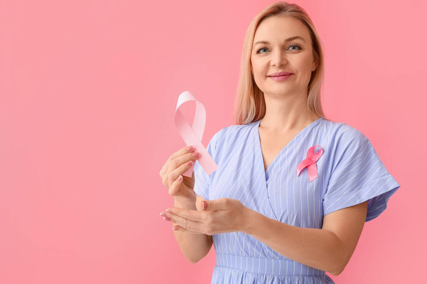 Woman with pink awareness ribbons on color background. Breast cancer awareness concept - Fotografie, Obrázek