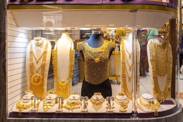 Dubai Gold Souk - золотые украшения - массивные золотые ожерелья, доспехи, кольца и шляпы отображаются в золотом магазине. - Фото, изображение