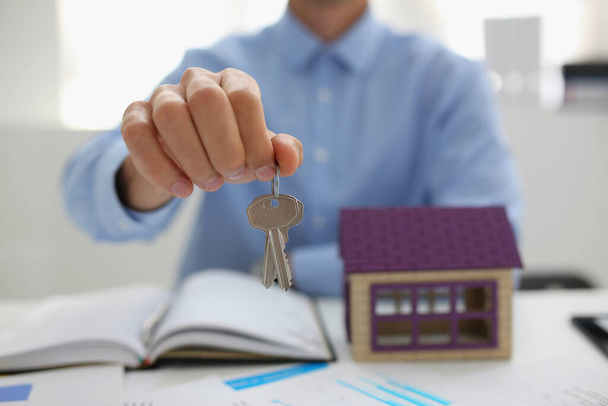 Male worker in suit give key to unlock new miniature house, buy new accommodation - Fotoğraf, Görsel