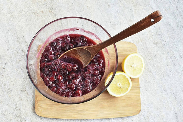 Heat the cherry again for 5-7 minutes. Remove from microwave and squeeze lemon juice. See to taste, one or two spoons. Frozen cherries are usually not too bright in taste and lemon juice is very appropriate here. Return the bowl to the microwave and  - Foto, imagen