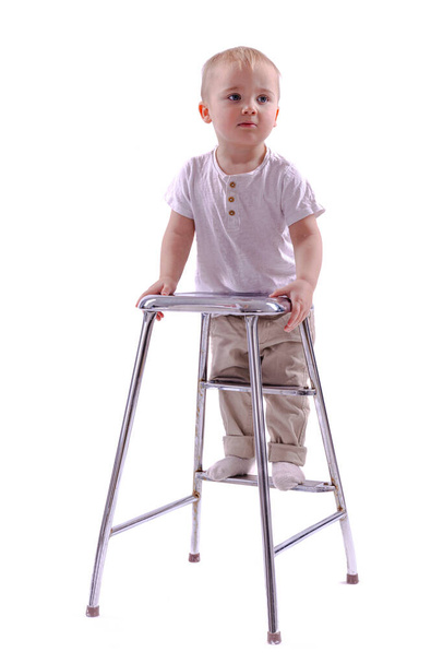 little boy sitting on a chair and looking at camera isolated on white background - Foto, Imagen