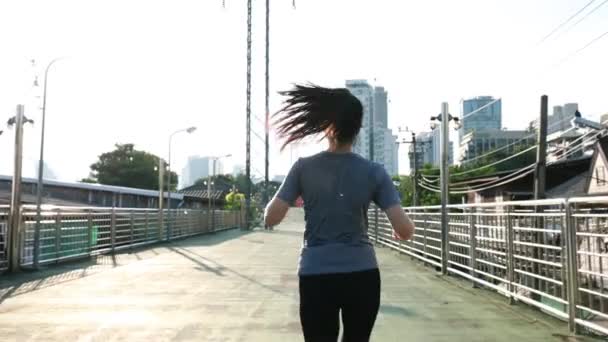 Vrouwelijke Kaukasische Aziatische atleet op straat in de stad. Trainen cardio joggen workout lifestyle op straat bij zonsondergang. Gezonde levensstijl. - Video