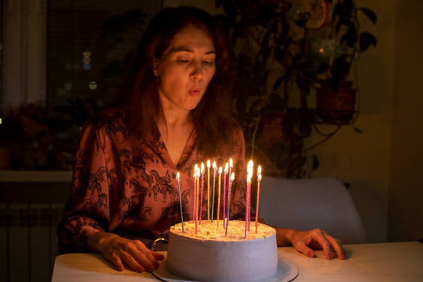happy girl blows out the candles on the cake at her birthday, - Fotó, kép