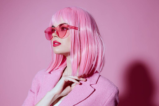 Porträt einer jungen Frau in rosa Brille Kosmetik Glamour Emotionen Farbhintergrund unverändert - Foto, Bild