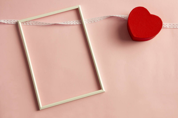 White frame on pink background and red heart - Foto, imagen