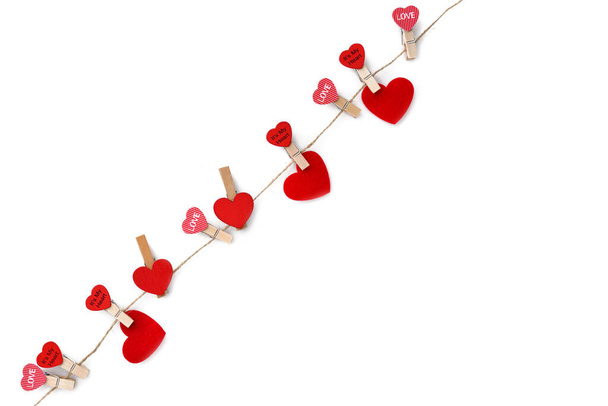 Wäscheklammern mit roten Herzen auf Seil isoliert auf weißem Hintergrund. Ansicht von oben. Grußkarte vorhanden. Platz für Ihren Text - Foto, Bild