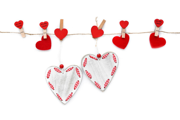 Clothespins with red hearts on rope isolated on white background. Top view. Greeting card. Space for your text - Foto, Imagem