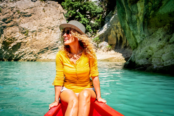 Carino donna turista adulta godere di attività ricreative all'aperto seduto kayak esperienza tour su un fiume blu acqua pulita. Vacanze estive e allegre donne che si divertono sulla barca - Foto, immagini