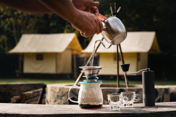 Tiputa kahvia mies kaatamalla kuumaa vettä kahvin maahan suodattimella. - Valokuva, kuva