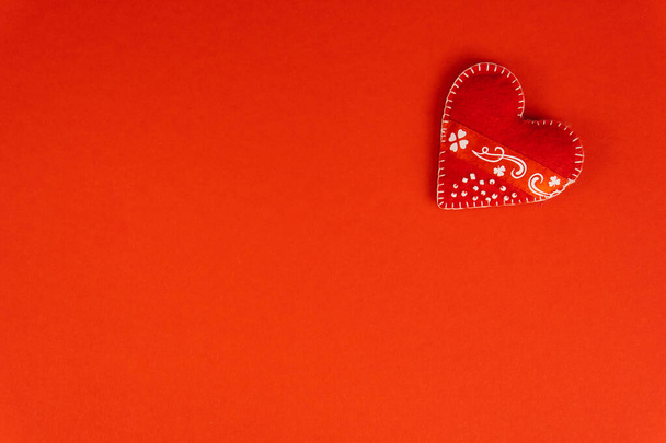 Top view Koncepcja Walentynek z przestrzenią do kopiowania. Czerwone serce tekstylne na czerwonym tle papper - Zdjęcie, obraz