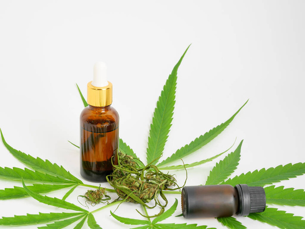 Glasflasche CBD-Öl Cannabisextrakt Marihuana Blatt und Knospe auf weißem Hintergrund, medizinisches Kräuterkonzept. - Foto, Bild