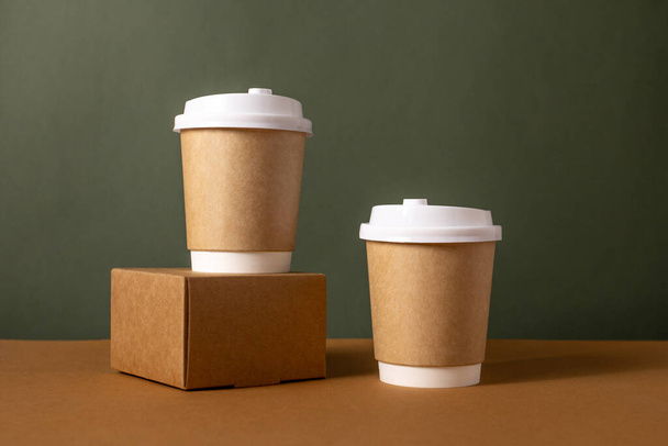 Koffie ambachtelijke papieren bekers met plaats voor logo op groene en bruine achtergrond, natuurlijke kleur, voor menu en restaurants  - Foto, afbeelding
