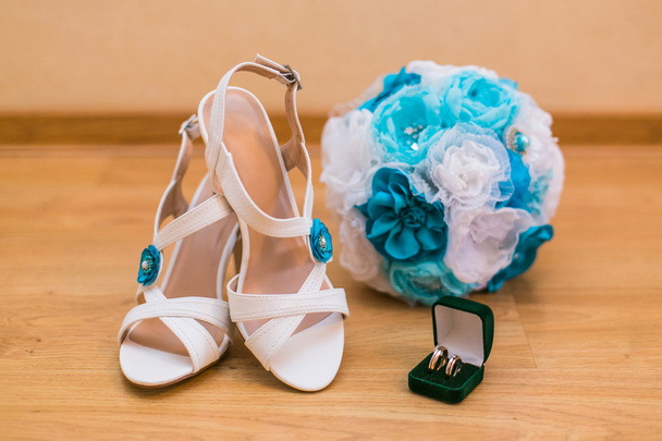 Close up of wedding bouquet and brides shoes and gold rings - Foto, imagen