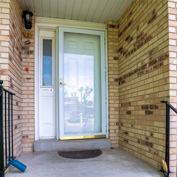Porte avant carrée d'une maison avec briques et balustrades métalliques - Photo, image