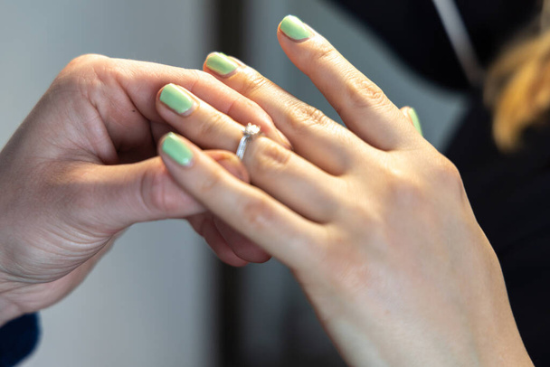 Er legt ihr nach einem Heiratsantrag einen Ring an den Finger - Foto, Bild