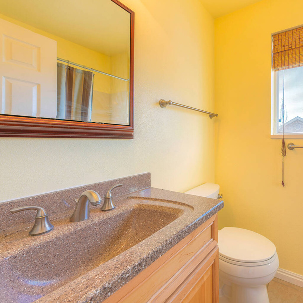Маленький желтый интерьер ванной комнаты с занавеской на окне - Фото, изображение