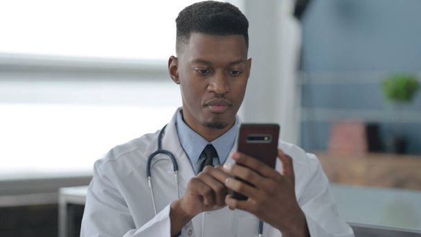 Portrait of African Doctor using Smartphone - Valokuva, kuva