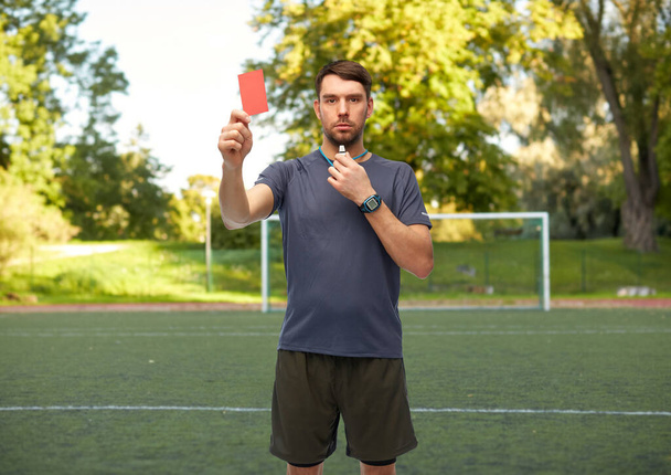 árbitro de fútbol con silbato mostrando tarjeta roja - Foto, imagen
