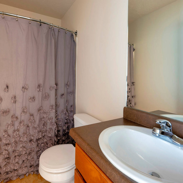Quadratische Innenausstattung eines kleinen Badezimmers mit braunem Vorhang mit 3D-Design - Foto, Bild