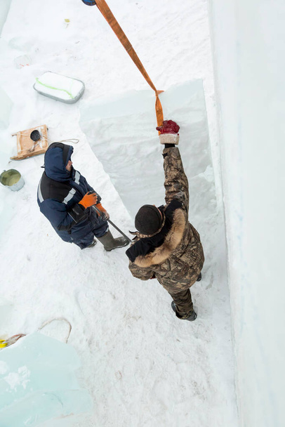Slingers unload ice slabs with a truck crane - Photo, Image