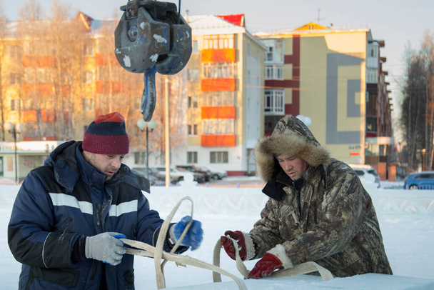 Arbeiders-slingers in winteruniformen met een tape in hun handen - Foto, afbeelding