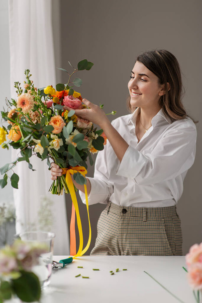 happy woman with bunch of flowers at home - Фото, зображення