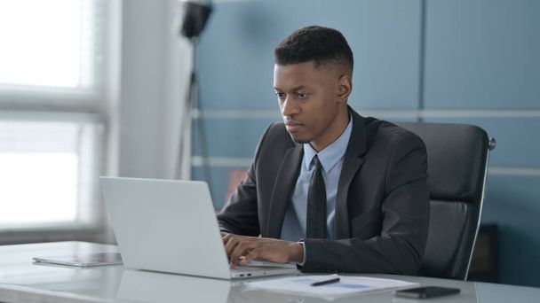 Homme d'affaires africain travaillant sur ordinateur portable dans le bureau - Photo, image