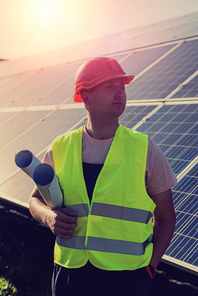 pracovník stojí s projektem v blízkosti solárních panelů - Fotografie, Obrázek