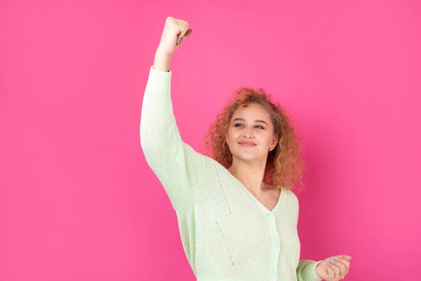 Happy young girl raises her fist up in delight! Successful victory gestures. - Foto, afbeelding