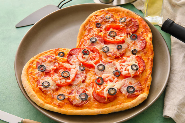 Plate with tasty heart-shaped pizza on table. Valentine's Day celebration - Foto, imagen