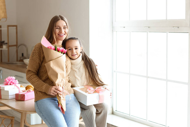 Happy mother with presents and her little daughter in kitchen on International Women's Day - Foto, Bild