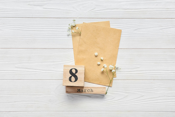 Blank greeting card for International Women's Day, gypsophila flowers and cube calendar with date MARCH 8 on white wooden background - Fotoğraf, Görsel