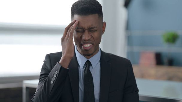 Porträt eines afrikanischen Geschäftsmannes mit Kopfschmerzen - Foto, Bild