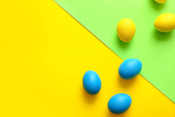 Синьо-жовті великодні яйця на кольоровому фоні
 - Фото, зображення