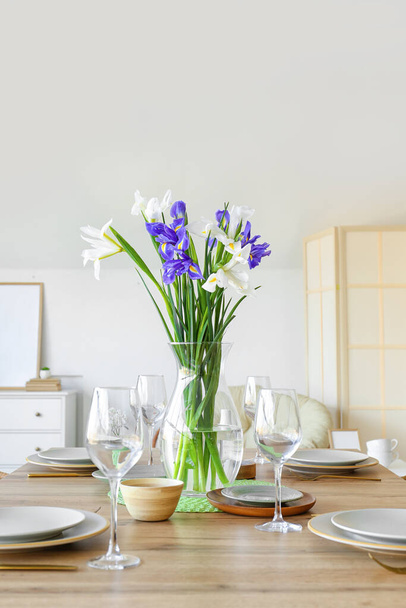 Vaso com flores de íris na mesa de jantar servida para a celebração do Dia Internacional da Mulher - Foto, Imagem