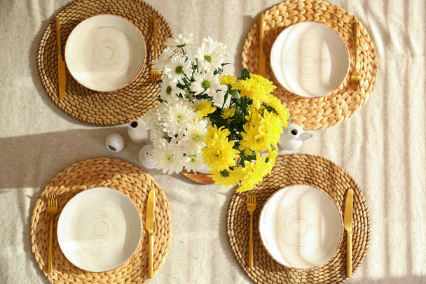 Platos, cubiertos y hermosas flores en la mesa de comedor servido para la celebración del Día Internacional de la Mujer - Foto, imagen
