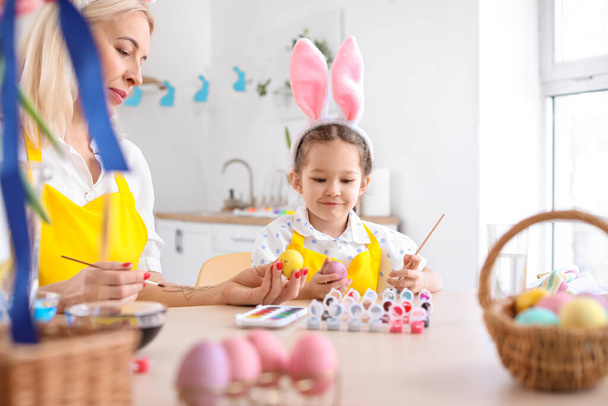 Pieni tyttö ja hänen isoäitinsä maalaavat pääsiäismunia kotona - Valokuva, kuva