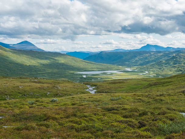 Hermoso paisaje del norte, tundra en Laponia sueca con río y lago ártico azul, verdes colinas y montañas en la ruta de senderismo Padjelantaleden. Día de verano, cielo azul, nubes blancas - Foto, Imagen