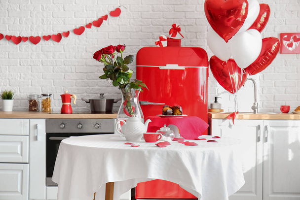 Обідній стіл з букетом троянд поданий на честь Дня святого Валентина на кухні. - Фото, зображення