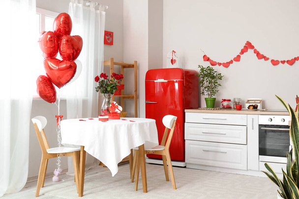 Обідній стіл з трояндами і подарунковими коробками для святкування Дня святого Валентина у світлій кухні. - Фото, зображення