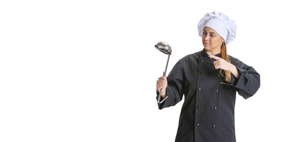 Happy beautiful young woman, lady-cook, chef in black uniform isolated on white background. Cuisine, profession, business, food, taste, restaurant concept. - Foto, imagen