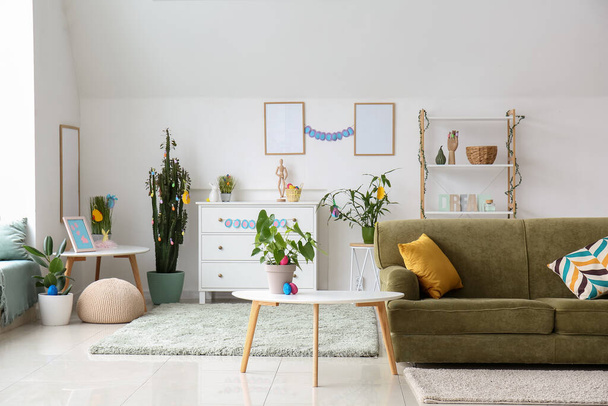 Interior of light living room with green sofa and Easter eggs - Photo, image