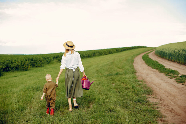 Beautiful mother with little son in a summer field - Фото, зображення