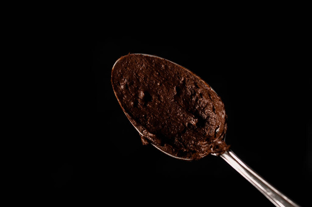 Κανάτα με λιωμένη σοκολάτα σε σκούρο φόντο - Φωτογραφία, εικόνα