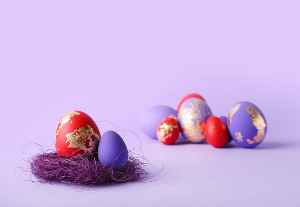 Stylish Easter eggs on purple background - Fotoğraf, Görsel