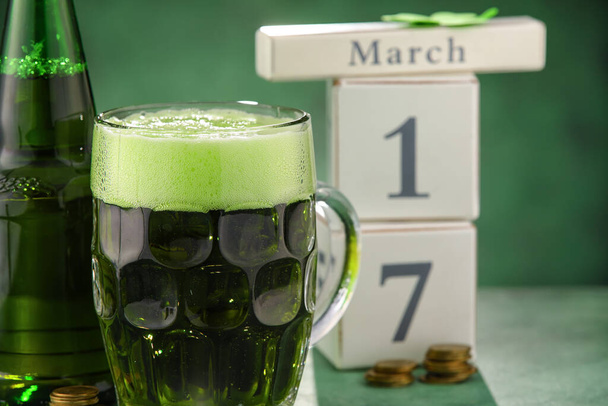 Γυαλί και μπουκάλι μπύρα σε πράσινο φόντο. Γιορτή του Αγίου Πατρικίου - Φωτογραφία, εικόνα