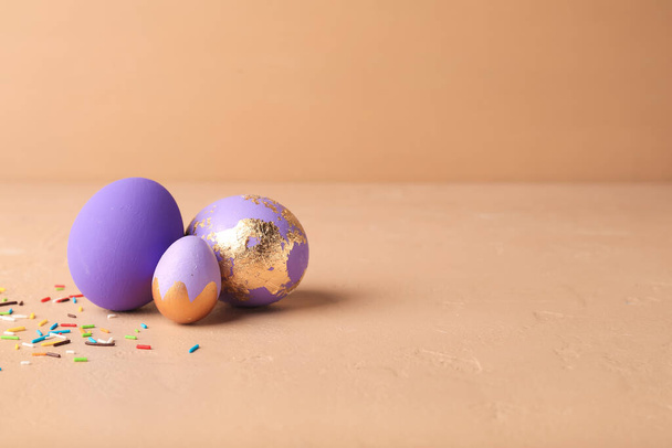 Beautiful Easter eggs and sprinkles on beige background - Photo, Image