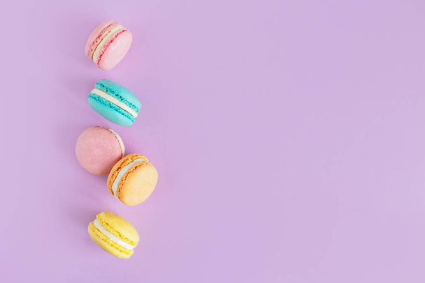 Tasty french macaroons on a violet pastel background.  Place for text. - Valokuva, kuva