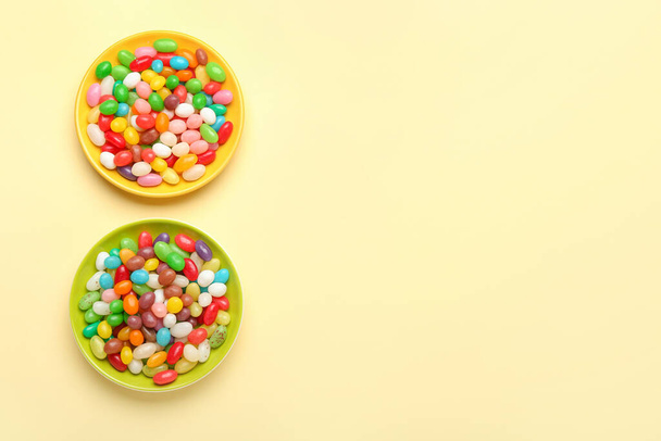 Plates with different jelly beans on beige background - Fotoğraf, Görsel